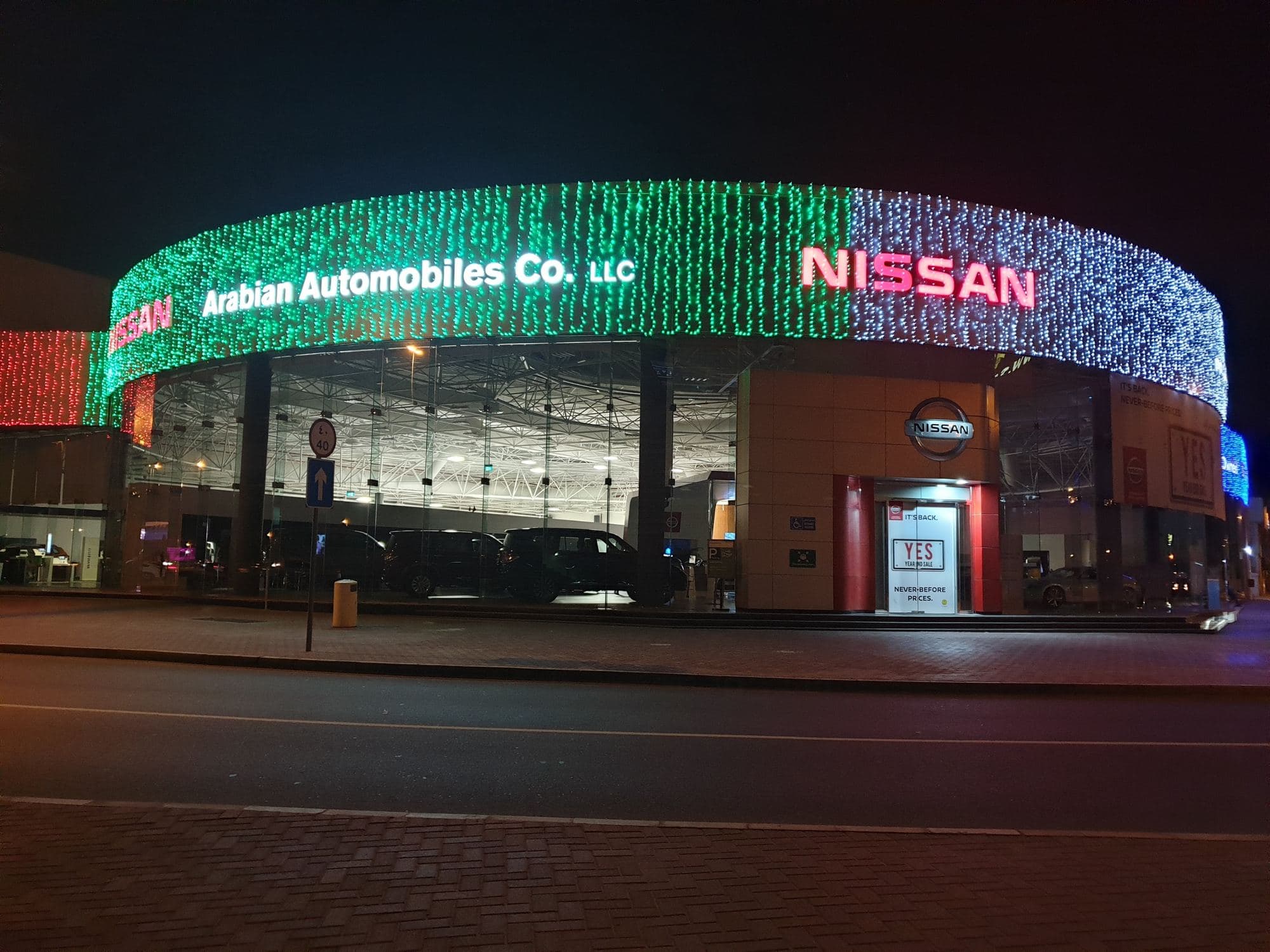 A showroom facade covered in festive curtain lights at night