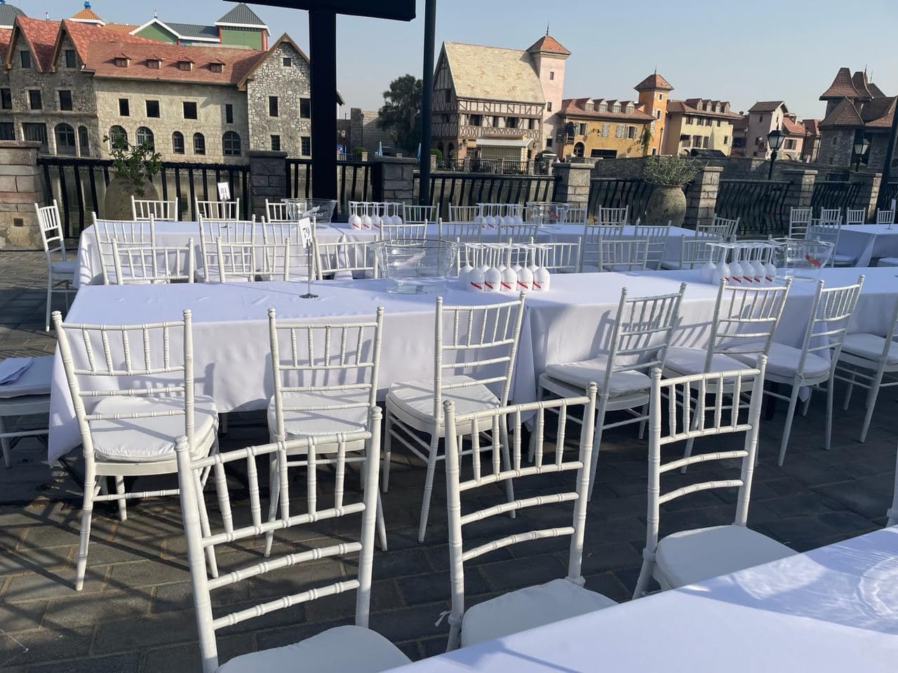 Long banquet tables with white cloths and chairs set outdoors