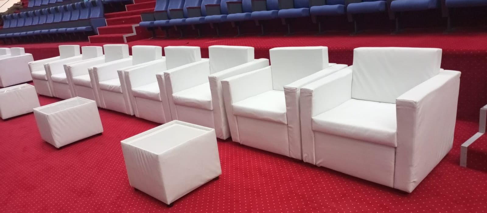 White lounge armchairs and cubes on a red carpet