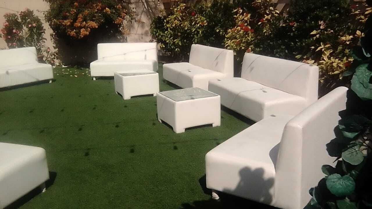White lounge sofas and cubes arranged on a lawn