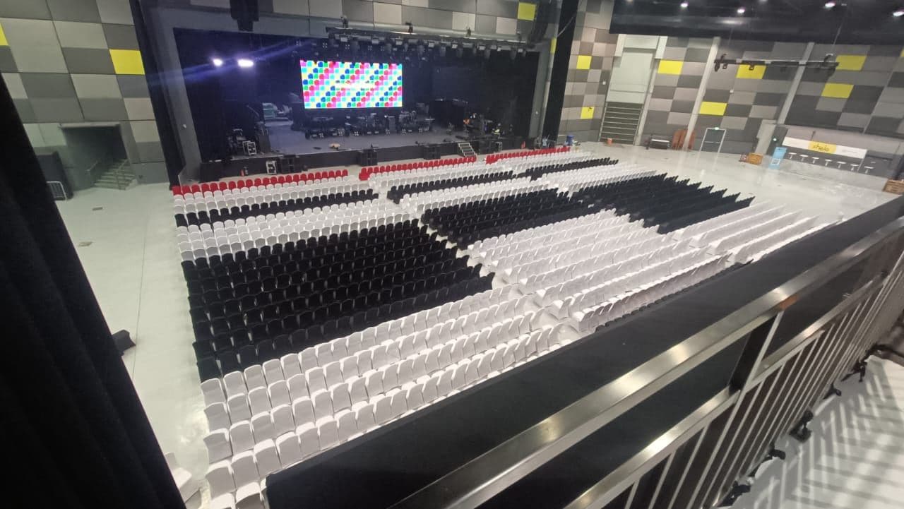Theatre-style seating in rows facing a stage with a screen