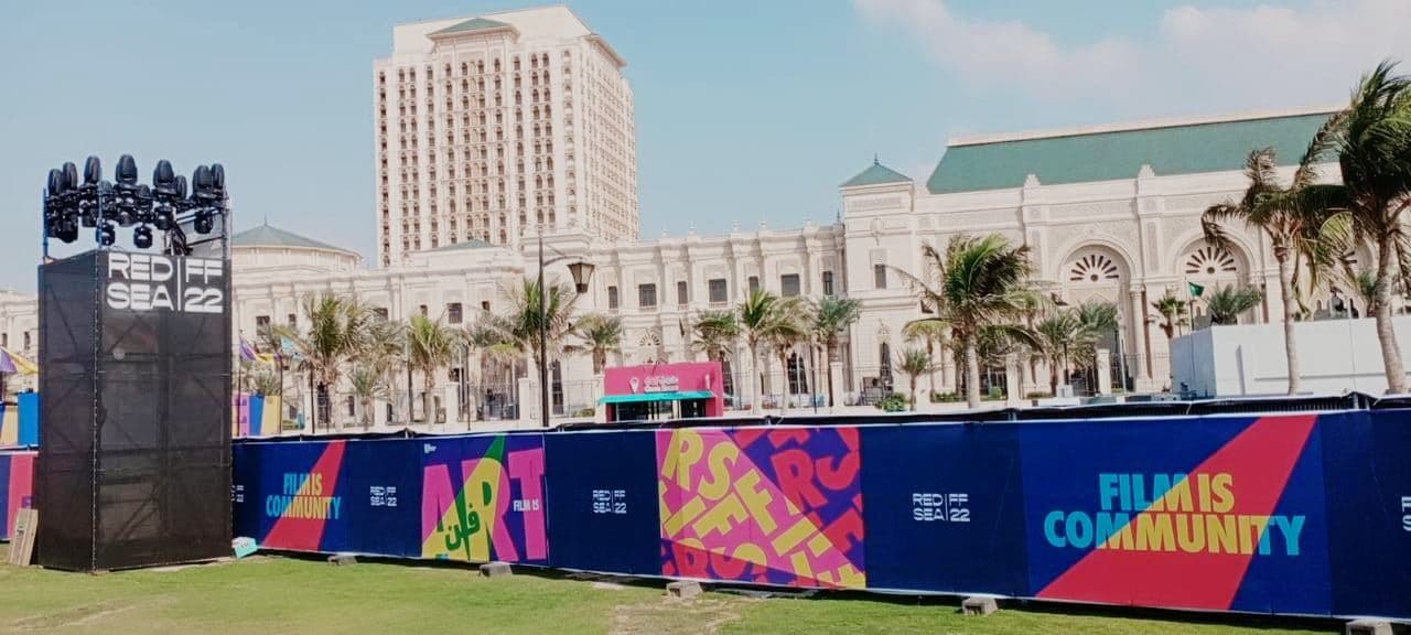 A long line of branded fencing near an event stage