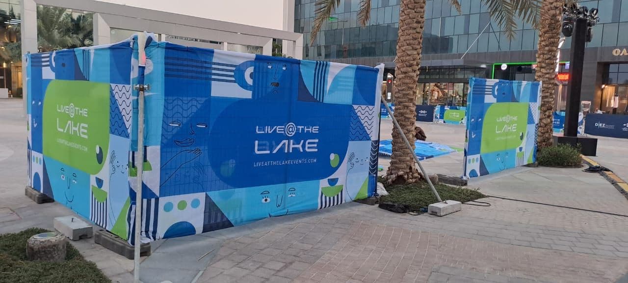 Temporary fencing wrapped in printed graphics by a lakeside venue