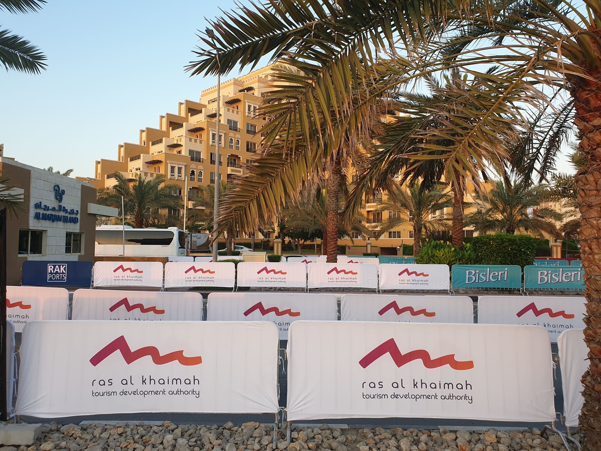 White printed barrier covers along a palm-lined road