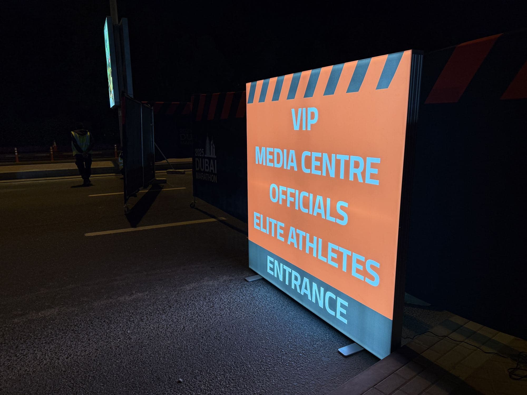 An illuminated directional light box sign at night