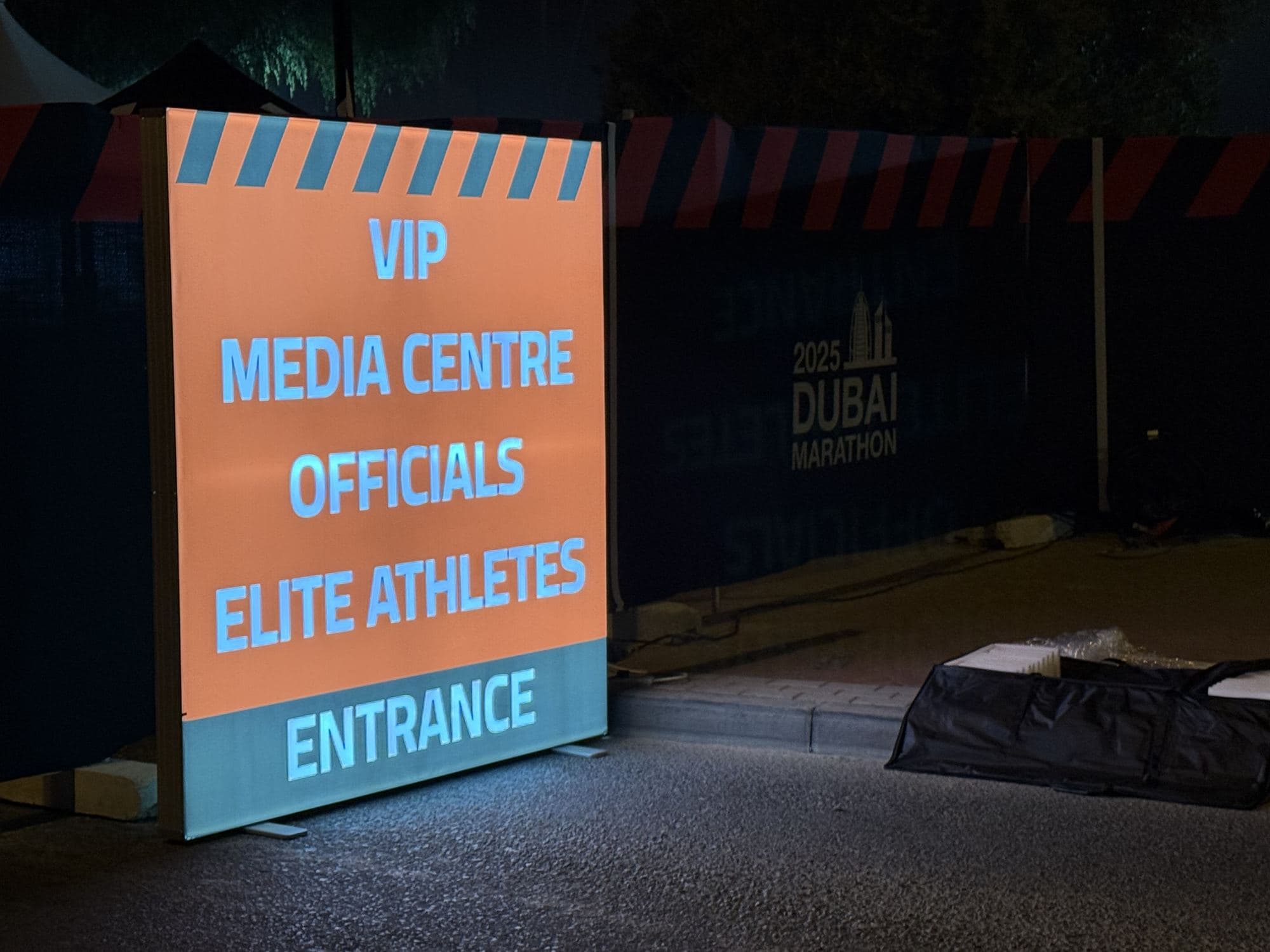 A backlit light box sign standing at an event entrance