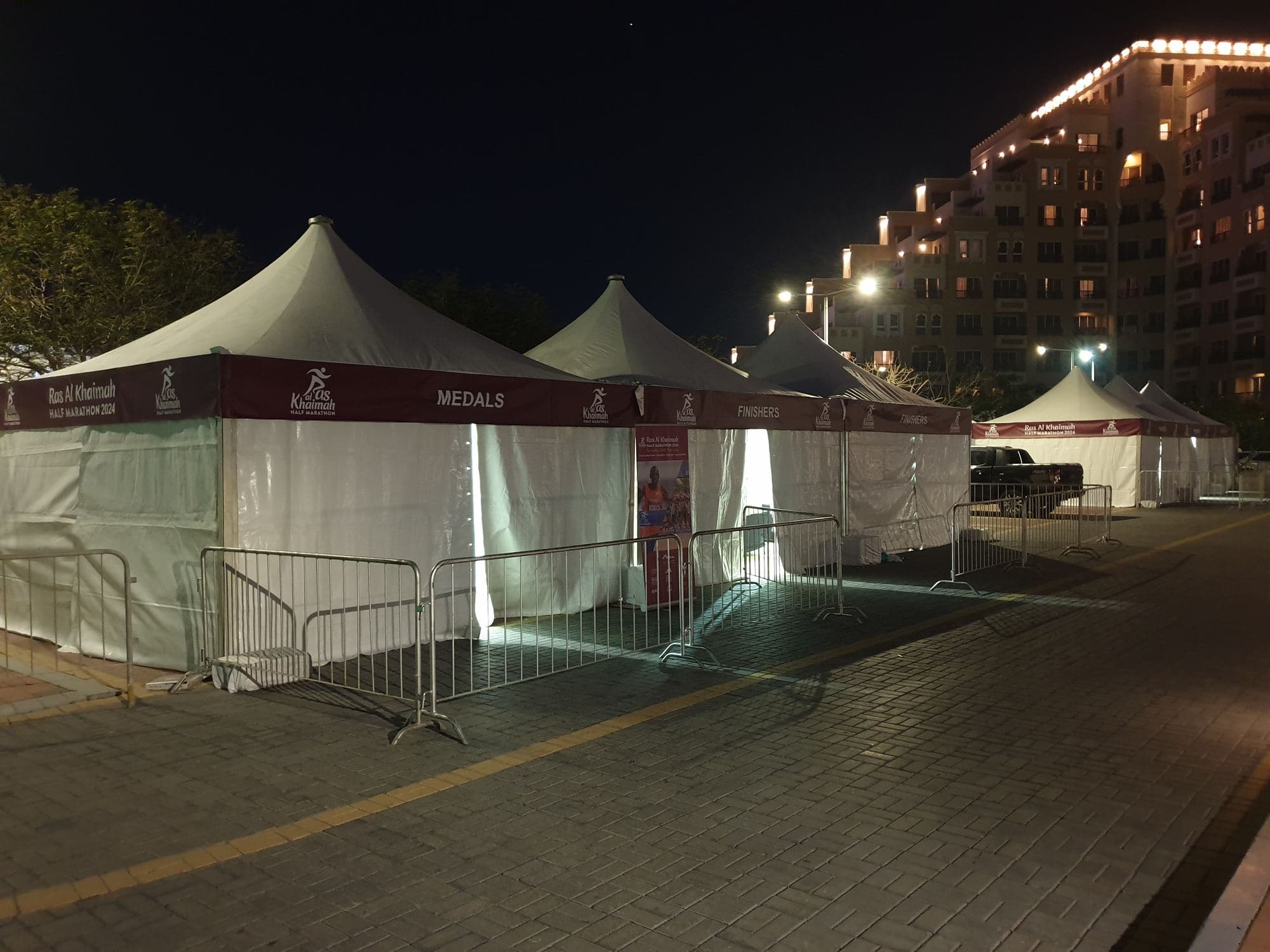 Branded peak tents set up for an outdoor event at night